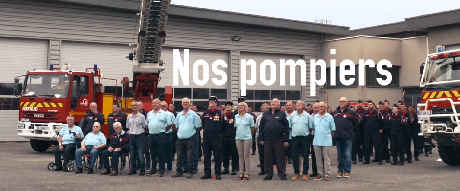Sapeurs-pompiers posant devant la caserne pour la photo du calendrier